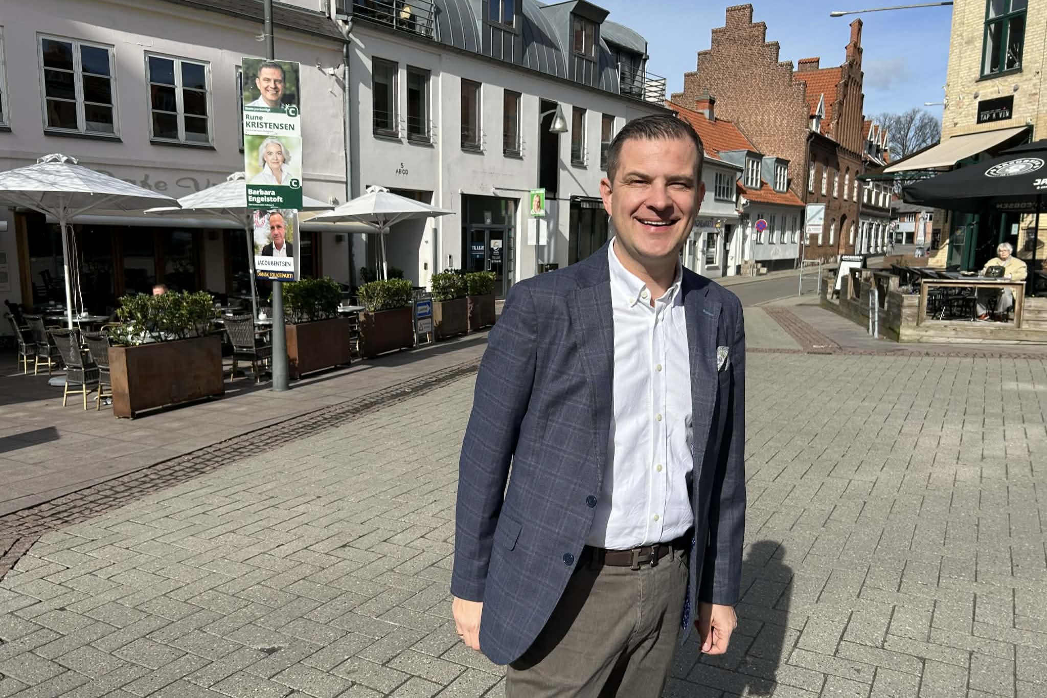 Rune Kristensen fanget i "café-hjørnet" i Næstved. Bag ham hænger han på lygtepælen over sin partikollega, Barbara Engelstoft, som stiller op for Næstved, men bor i Gentofte. Foto: John Ringstrøm