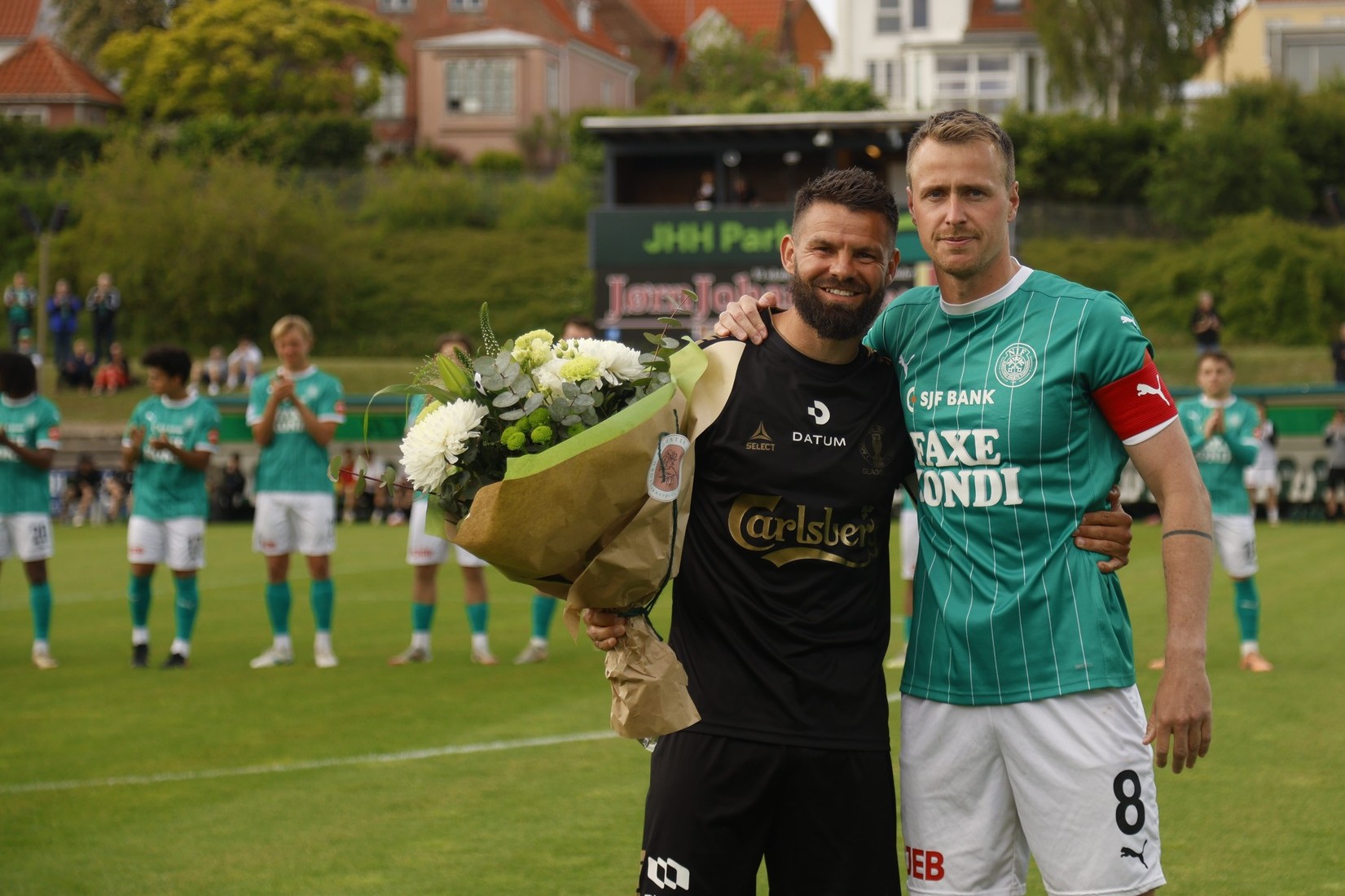 Næstveds anfører overrakte inden kampen "oprykningsblomster" til ABs anfører Marc Dal Hende (t.v.). Foto: Næstved Boldklub