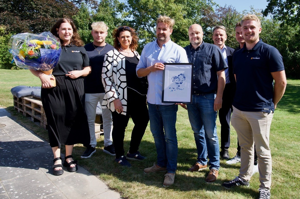 Carl-Ole Holbøll med kunstneren Ole Ingstrups udgave af Venstres Blå Blomst. Ved siden af ham står Pernille Sten (t.v.) og borgmesterkandidat Kenneth Sørensen. I baggrunden til højre ses Venstres folketingskandidat Christian Friis Bach. De øvrige er medarbejdere med ansvar for Holbølls lærlinge. Foto: Presse