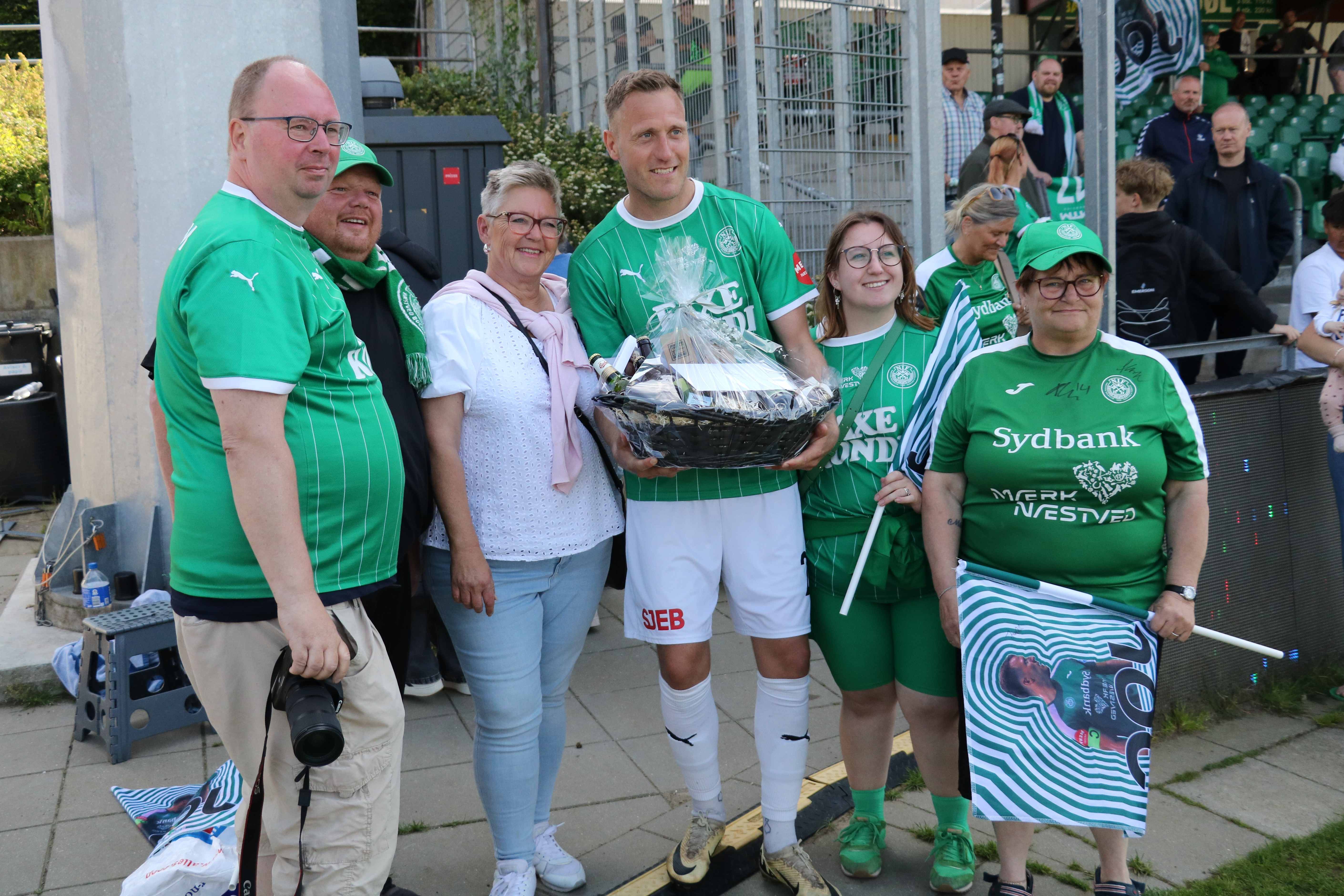 Næstved-anfører gennem mange år, Jesper Christiansen, omgivet af trofaste fans, der kom med gavekurv. Foto: John Ringstrøm
