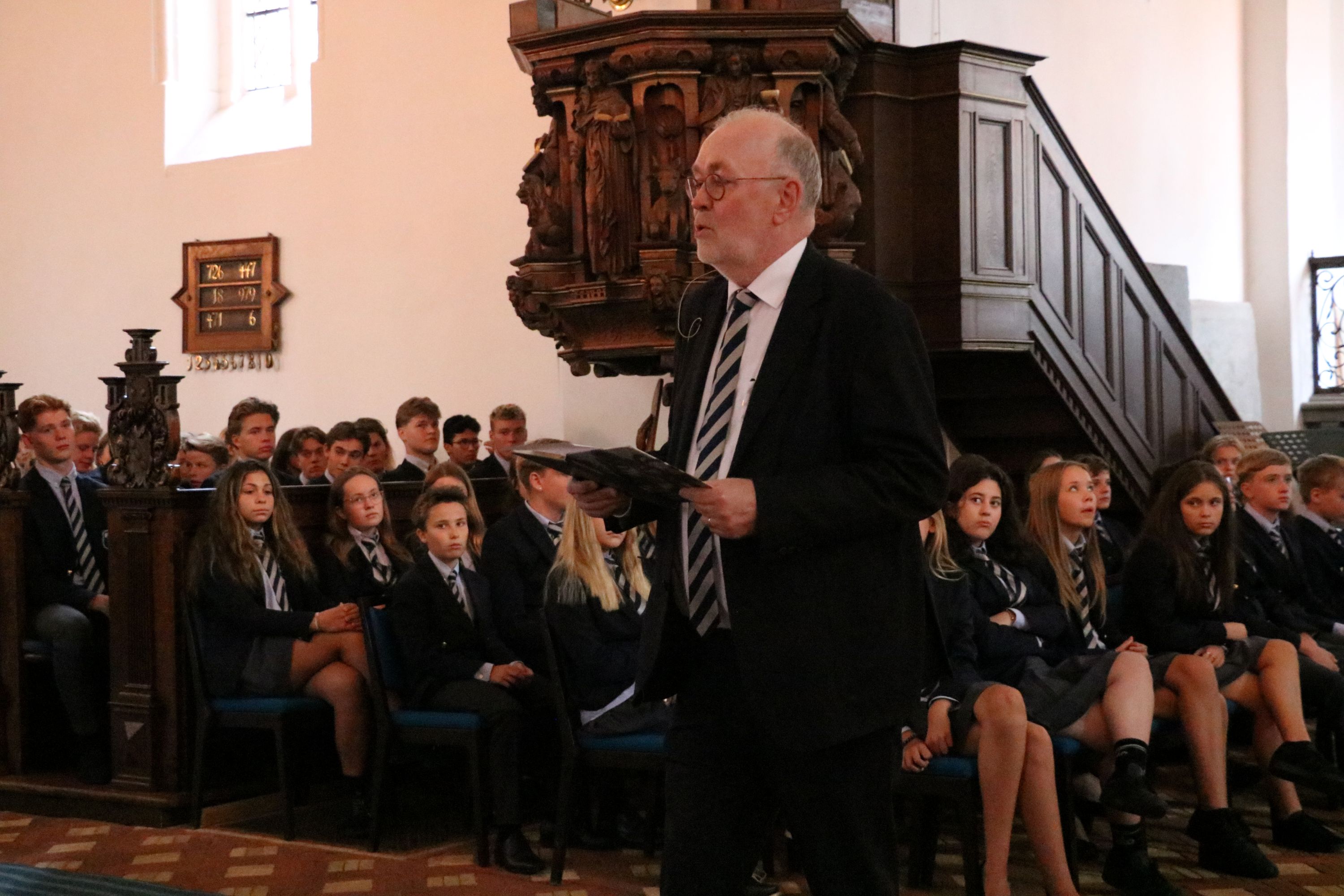 Rektor Jimmy Burnett bød velkommen og sang for på "I østen stiger solen op". Foto: John Ringstrøm