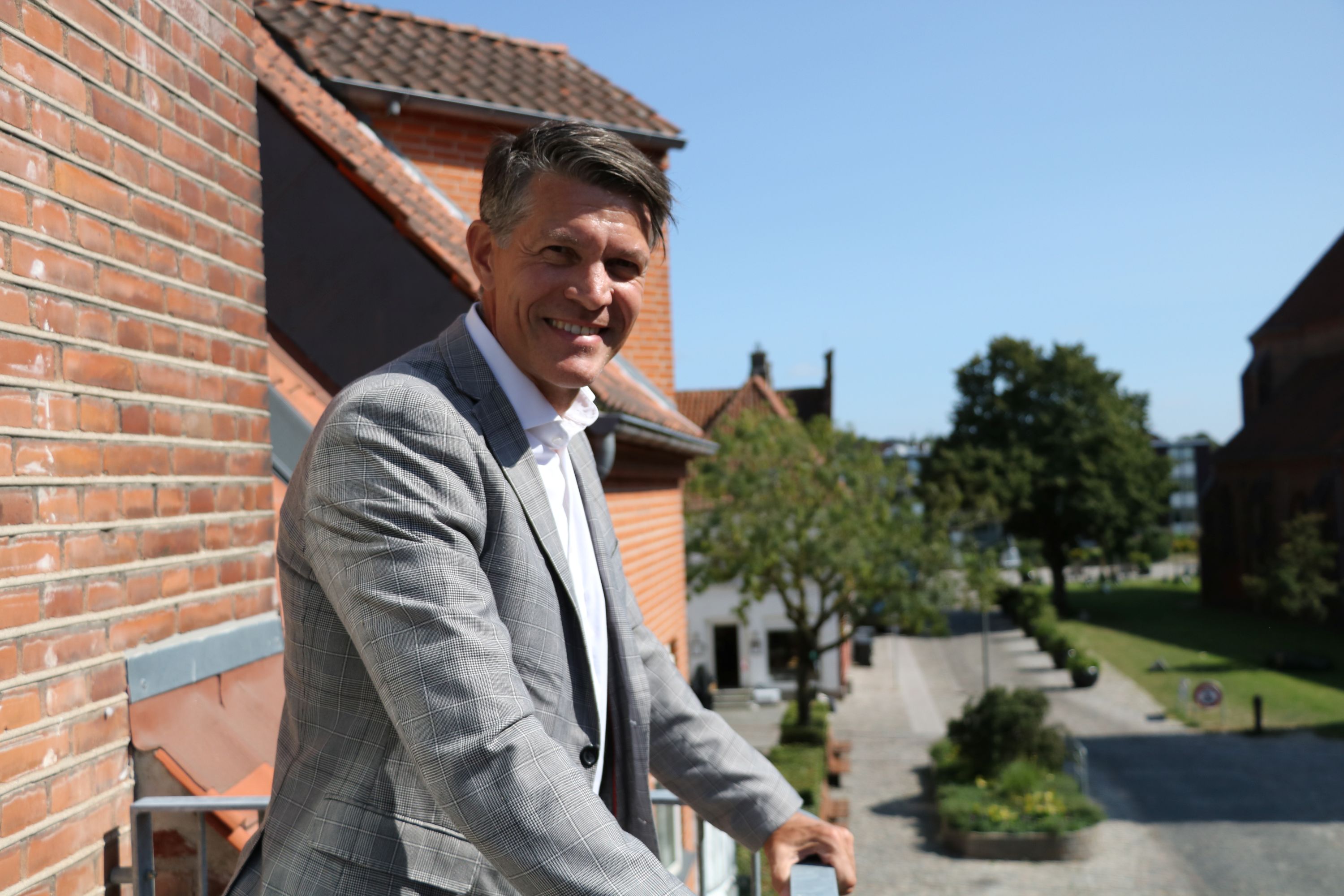 Lars Jørgensen med god udsigt til Sct. Peders Kirke fra bankens altan i Vinhusgade. Foto: John Ringstrøm