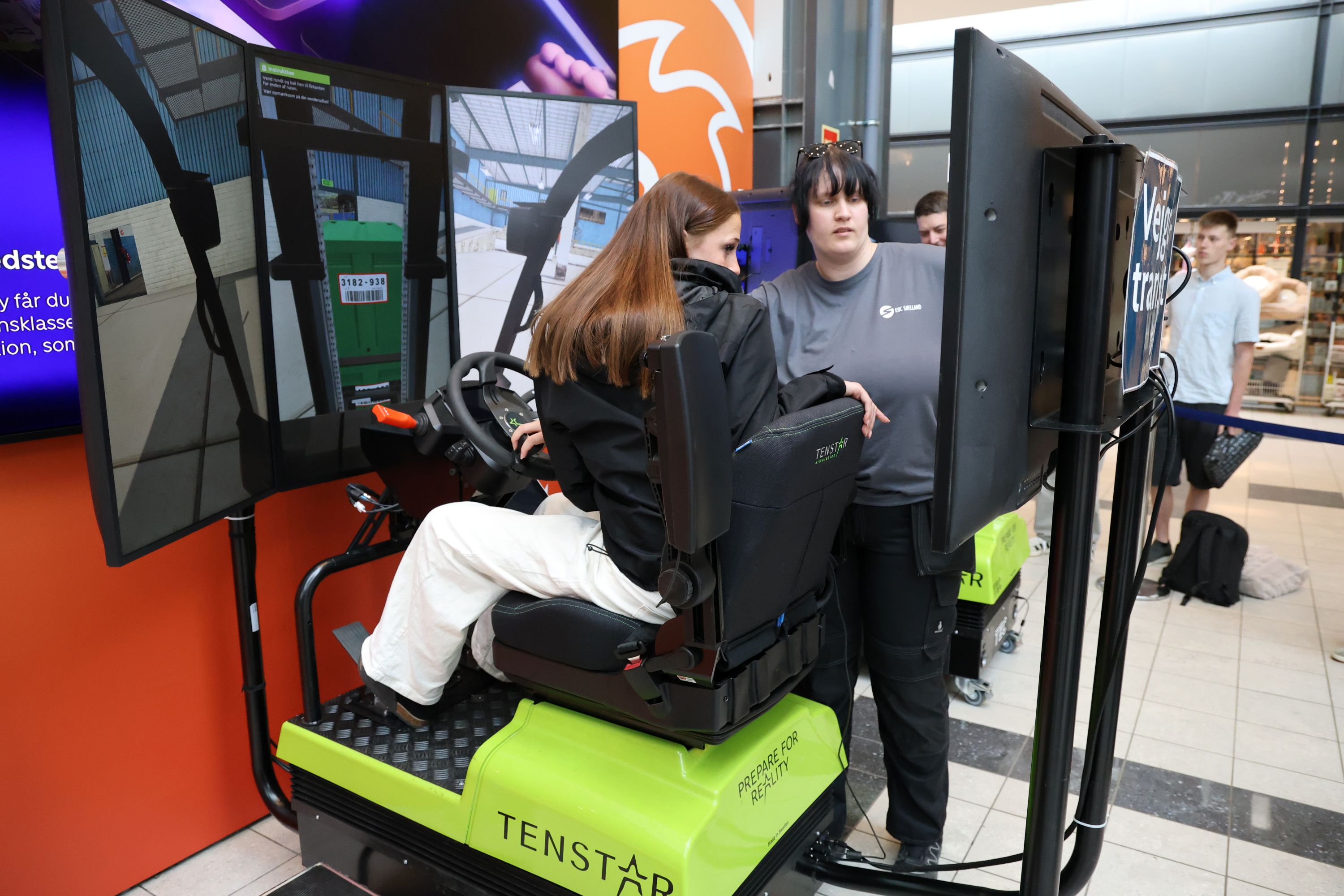 Mathilde fra Fladsåskolen prøver en truck-simulator og bliver vejledt af Laura (th) fra Lager og Terminaluddannelsen. Foto: John Ringstrøm