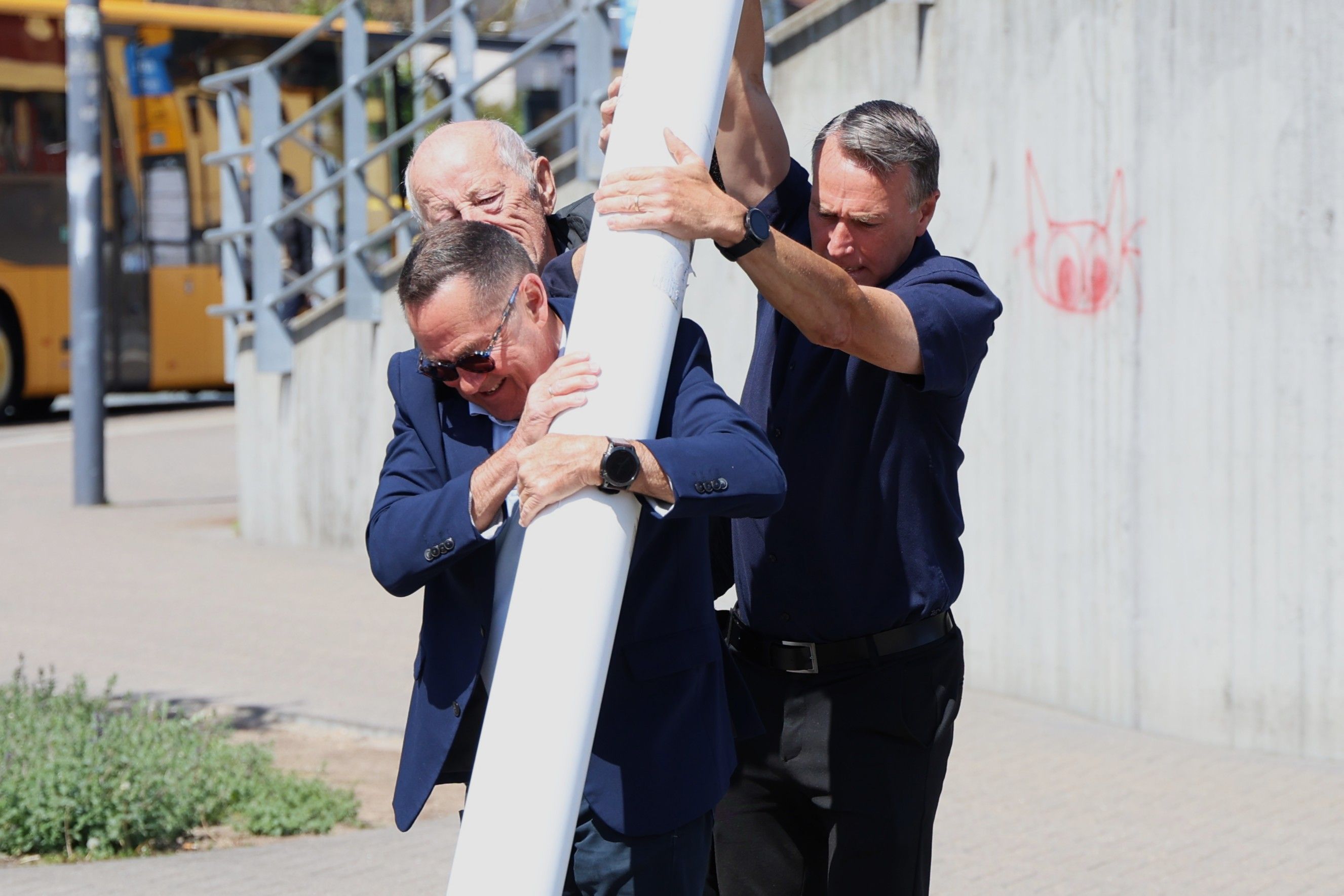 Benny Pedersen (forrest), Åge Petersen og Carsten Rasmussen (th) har styr på flagstangen. Foto: John Ringstrøm