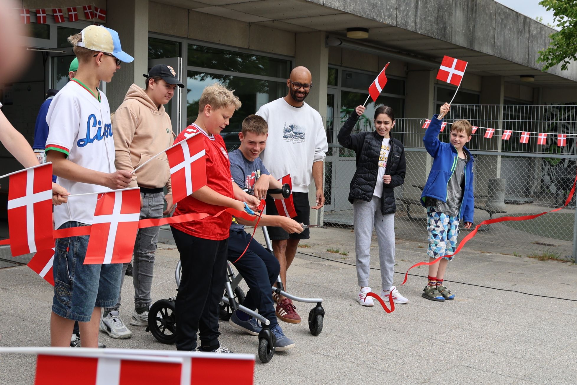 Eleverne Sebastian og Adam klipper den røde snor til stor begejstring for kammerater, lærere og forældre. Foto: John Ringstrøm