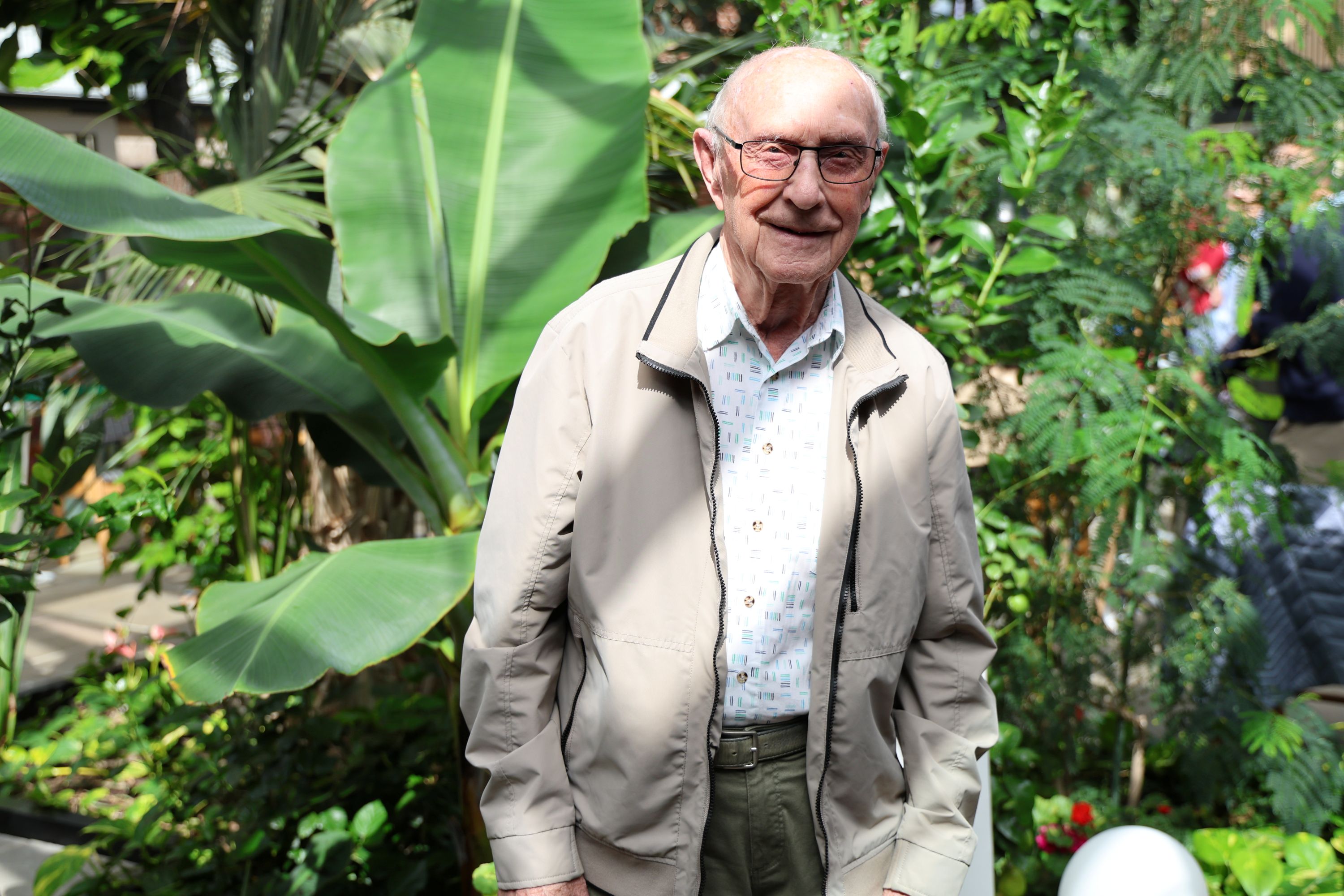 Børge Petersen på 90 år hentede for cirka 50 år siden bananplanten bag ham på Gisselfeld og plantede den i Solgavens vinterstue. Foto: John Ringstrøm