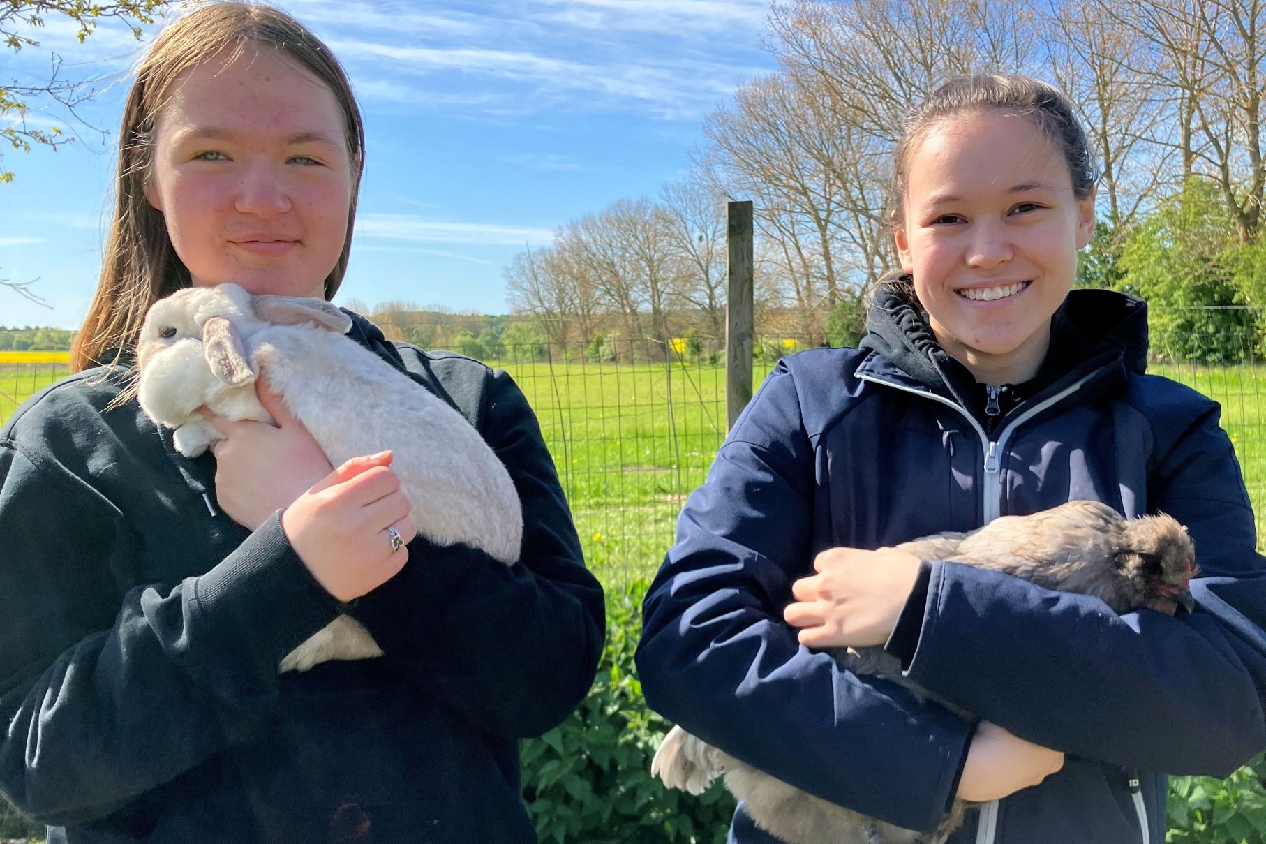 Clara og Karoline står med kaninerne "Giraffe og Cobber". Foto: Provstegaarden