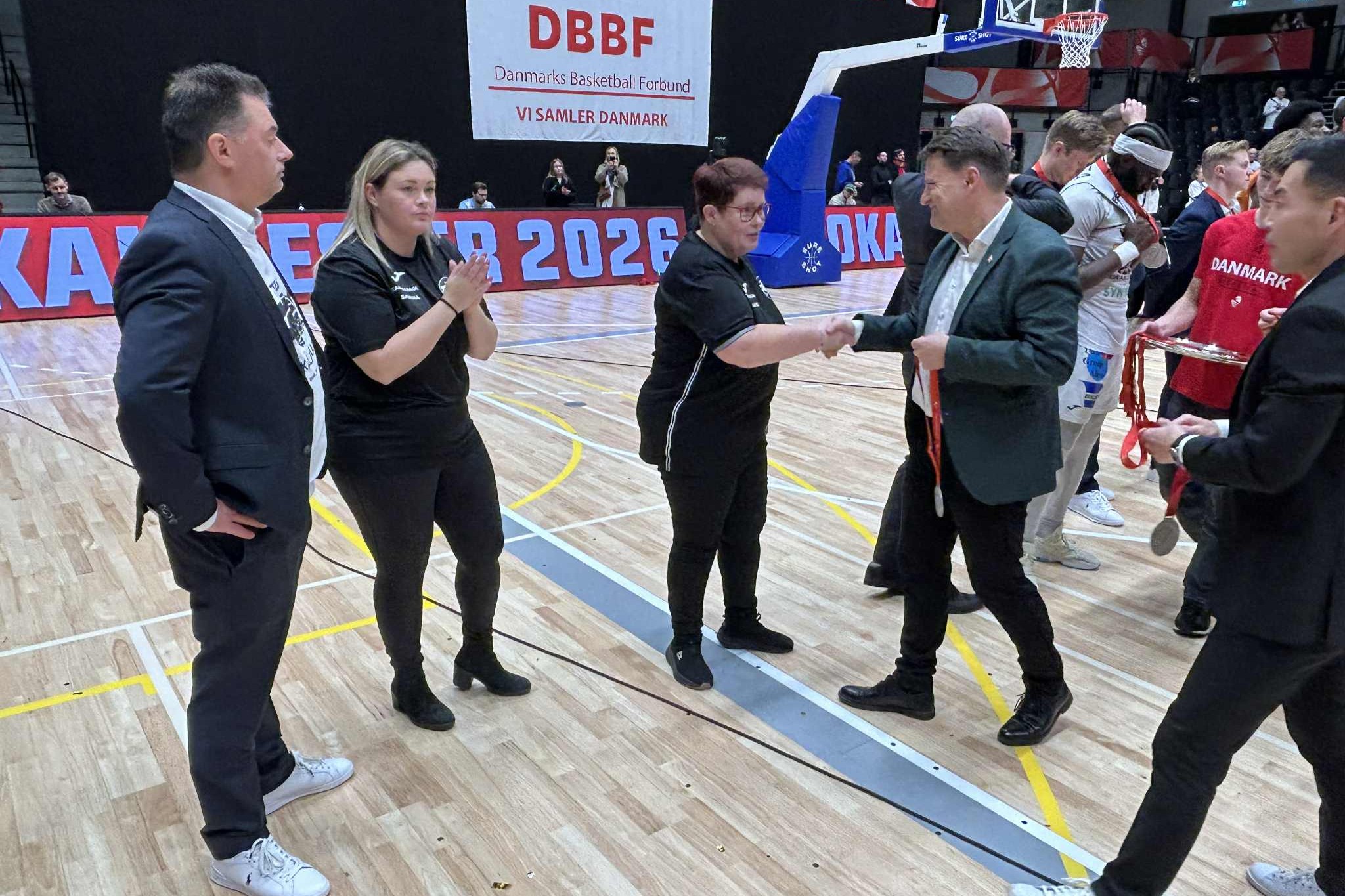 Direktør Andreas Larsen (t.v.) ser til, at holdlederne Hanne (th) og Sabrina Henriksen får sølvmedaljer. Foto: John Ringstrøm