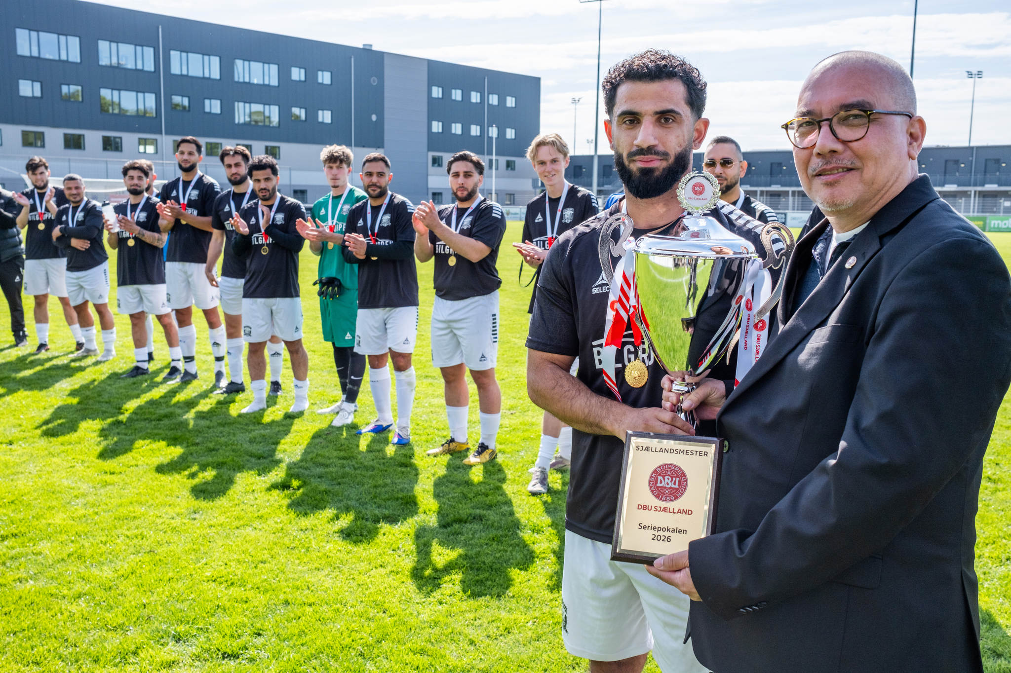 DBU Sjællands formand, Jakob Koed, overrækker pokalen til Roskilde United efter finaledramaet. Foto: DBU Sjælland / Kim Matthäi Leland