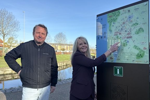 Et af de ni nye oplevelsesskilte er opsat ved Den Fritlagte Suså, og Formand for Beskæftigelses-, Erhvervs- og Turismeudvalget, Githa Nelander, glæder sig sammen med direktør Martin HH Bender, Visit Sydsjælland & Møn, over, at skiltene synliggør de mange oplevelser, Næstved Kommune har at byde på. Foto: Næstved Kommune